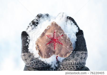 Mittens with heart on snow winter holidays concept Mittens with heart on snow winter holidays concept 76220405
