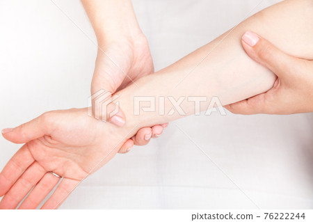 Woman receiving osteopathic treatment of her wrist 76222244