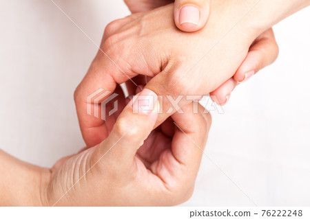 Woman receiving osteopathic treatment of her thumb 76222248