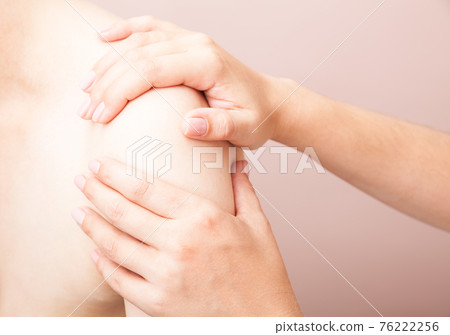Woman receiving osteopathic treatment of her shoulder 76222256