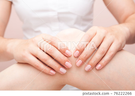 Woman receiving osteopathic treatment of her knee joint 76222266