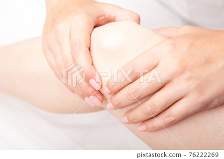 Woman receiving osteopathic treatment of her knee joint Woman receiving osteopathic treatment of her knee joint 76222269