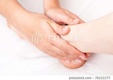 Woman receiving osteopathic treatment of her foot joint 76222277