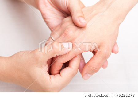 Woman receiving osteopathic treatment of her finger 76222278