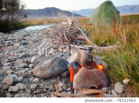 Cooking camp food in cauldron on open fire outdoors Cooking camp food in cauldron on open fire outdoors 76222463