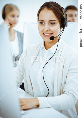 Call center. Group of diverse operators at work. Beautiful woman in headset communicating with customers of telemarketing service. Business concept Call center. Group of diverse operators at work. Beautiful woman in headset communicating with customers of telemarketing service. Business concept 76222469
