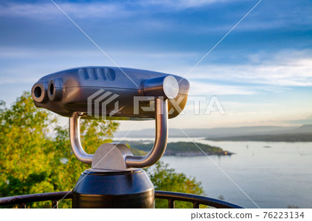 Tourist telescope over Oslo cityscape at sunset Norway 76223134