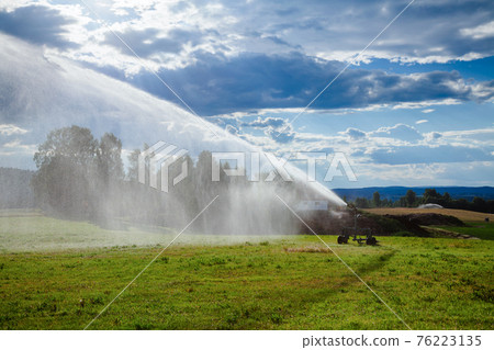 Watering field with portable sprinkler irrigation machine during a drought 76223135