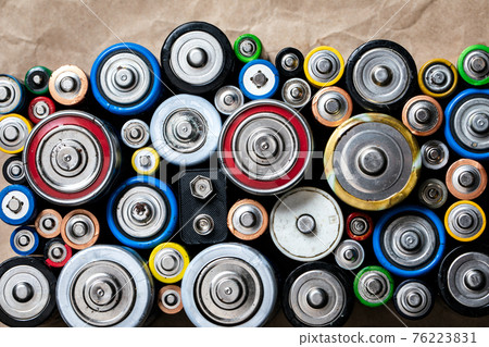 Used Alkaline batteries on recycled paper toxic waste recycling and ecology issues concept background 76223831