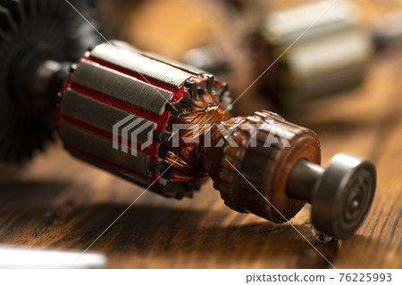 Power tool repair. Details of electrical appliance and repair tools on a wooden table in a repair shop Power tool repair. Details of electrical appliance and repair tools on a wooden table in a repair shop 76225993