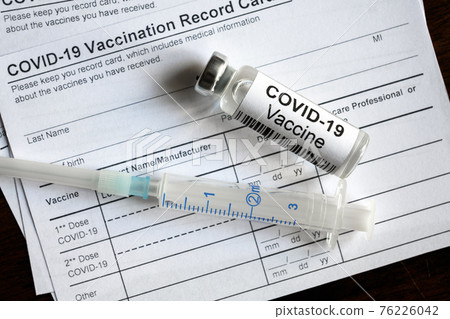 COVID-19 vaccine bottle and syringe are on coronavirus Vaccination Record Card COVID-19 vaccine bottle and syringe are on coronavirus Vaccination Record Card 76226042