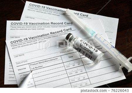 COVID-19 Vaccination Record Card on desk, coronavirus immunization certificate 76226043