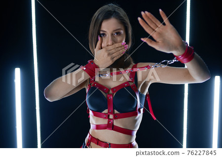 Sexy lady in red leather handcuffs, bdsm style 76227845