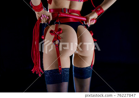 Sexy woman holds red leather whip, back view Sexy woman holds red leather whip, back view 76227847