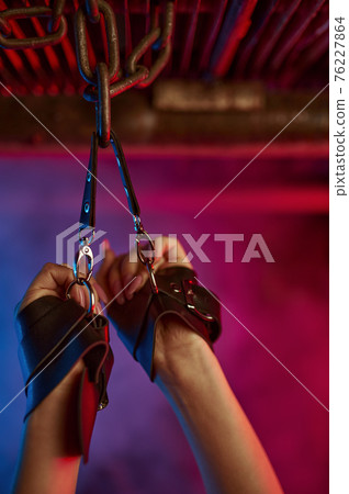 Female hands in leather bdsm handcuffs, fetish 76227864