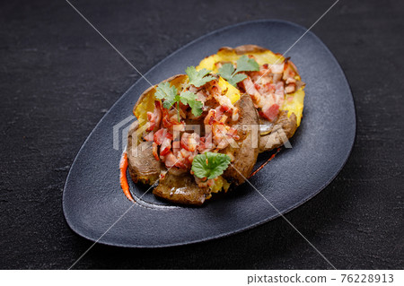 Baked whole smashed grilled potatoes with bacon 76228913