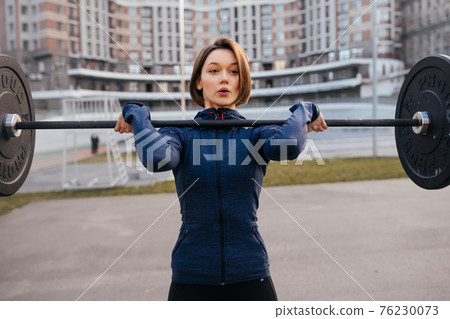Strong woman exercising with barbell. Sports, fitness concept. Strong woman exercising with barbell. Sports, fitness concept. 76230073