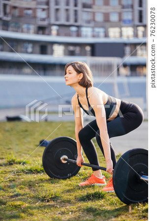 Strong woman exercising with barbell. Sports, fitness concept. 76230078