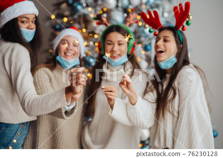 Multi-ethnic young people celebrating New year eve holding sparklers 76230128