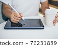 Female hands holding and using digital pen writing on taplet screen , freelance working business at home 76231889