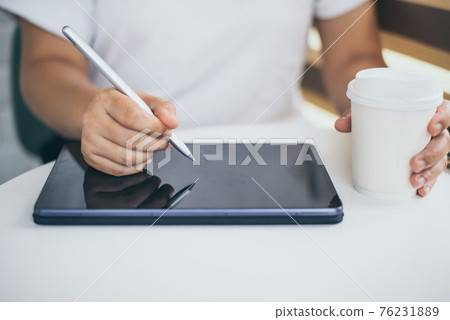 Female hands holding and using digital pen writing on taplet screen , freelance working business at home Female hands holding and using digital pen writing on taplet screen , freelance working business at home 76231889