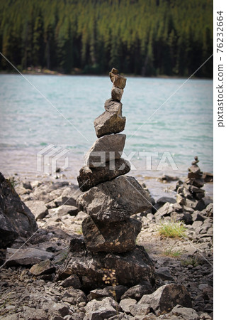 Cairn stacks built along a lake shore in summer Cairn stacks built along a lake shore in summer 76232664
