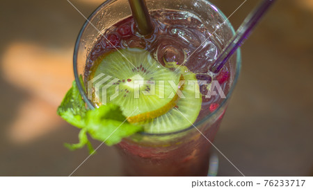Grape, Kiwi and Soda Juice in a clear glass. Grape, Kiwi and Soda Juice in a clear glass. 76233717
