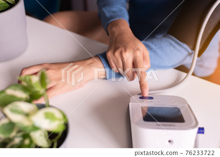 Patient woman hands using blood pressure & heart rate monitors in yourself at home Patient woman hands using blood pressure & heart rate monitors in yourself at home 76233722