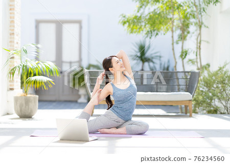 Woman doing yoga online Woman doing yoga online 76234560