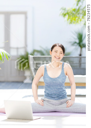 Woman doing yoga online Woman doing yoga online 76234575