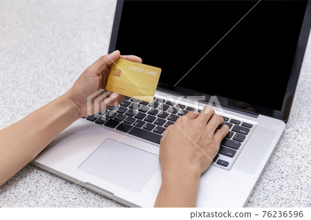 Young woman holding credit card and using laptop computer. Women working at home. Online shopping, e-commerce, internet banking, spending money, working from home concept. Technology shopping online Young woman holding credit card and using laptop computer. Women working at home. Online shopping, e-commerce, internet banking, spending money, working from home concept. Technology shopping online 76236596