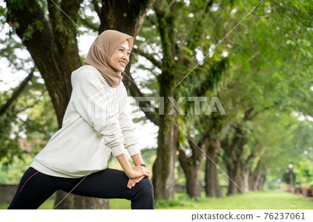 happy and fun muslim woman doing exercising outdoor in the morning 76237061
