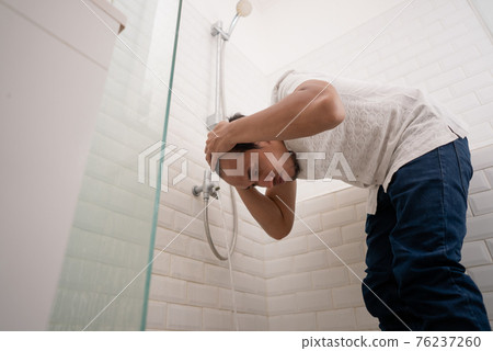 Young Muslim man perform ablution wudhu before prayer at home Young Muslim man perform ablution wudhu before prayer at home 76237260