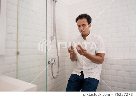 Muslim man praying after perform ablution (wudhu) at the bathroom Muslim man praying after perform ablution (wudhu) at the bathroom 76237278