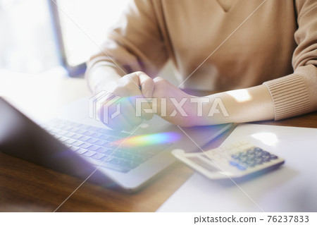 Woman operating a personal computer 76237833