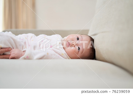 Asian baby lying on the sofa 76239059