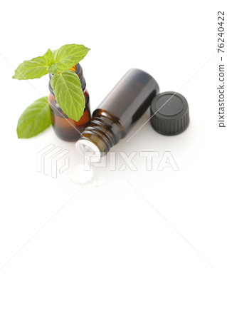 在白色背景上拍攝一瓶薄荷和香油 76240422