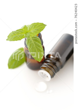 在白色背景上拍攝一瓶薄荷和香油 76240423