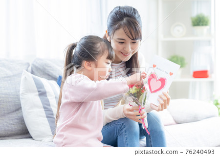 Family Girls and moms handing out bouquets and handmade cards on Mother's Day 76240493