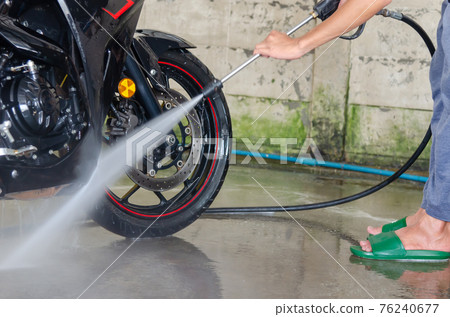 Clean up the motorcycle wash at the car wash shop 76240677