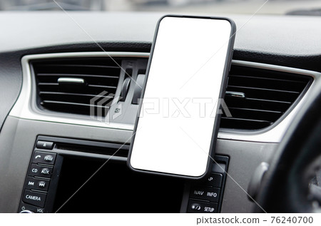 Mobile phone on the car air vent.Blank with white screen.Mock up smart phone in car. 76240700