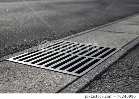 Metal drains on the side of concrete roads 76240990