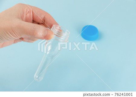 Female hand with PCR test kit for saliva 76241001