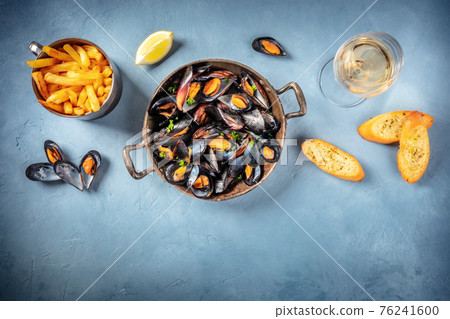 Mussels with wine, French fries, toasted bread, and lemon Mussels with wine, French fries, toasted bread, and lemon 76241600
