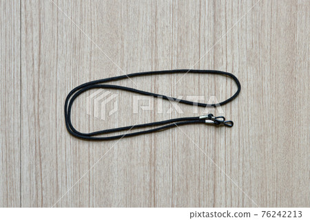 black eyeglasses strap on a wooden background 76242213