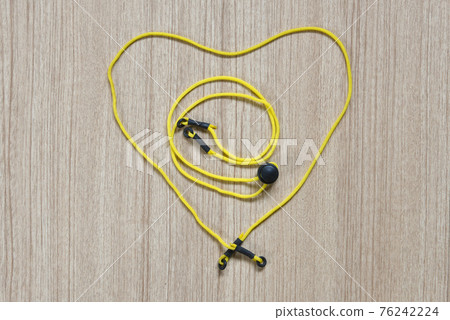 Yellow eyeglasses strap, placed in a heart shape, on a wooden background Yellow eyeglasses strap, placed in a heart shape, on a wooden background 76242224