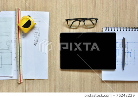 a top view of architect working desk with equipments for drawings pens sketched idea on wood table, the concept of modern technology for architectural working with tablet 76242229
