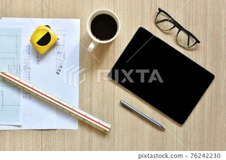 a top view of architect working desk with equipments for drawings pens sketched idea on wood table, the concept of modern technology for architectural working with tablet 76242230