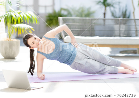 Woman doing yoga online 76242739