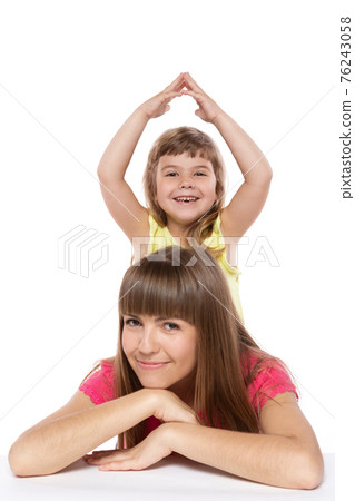 mom and little daughter are smiling, the child folded her arms over her head, like a house roof, family and safety concept, on a white background mom and little daughter are smiling, the child folded her arms over her head, like a house roof, family and safety concept, on a white background 76243058